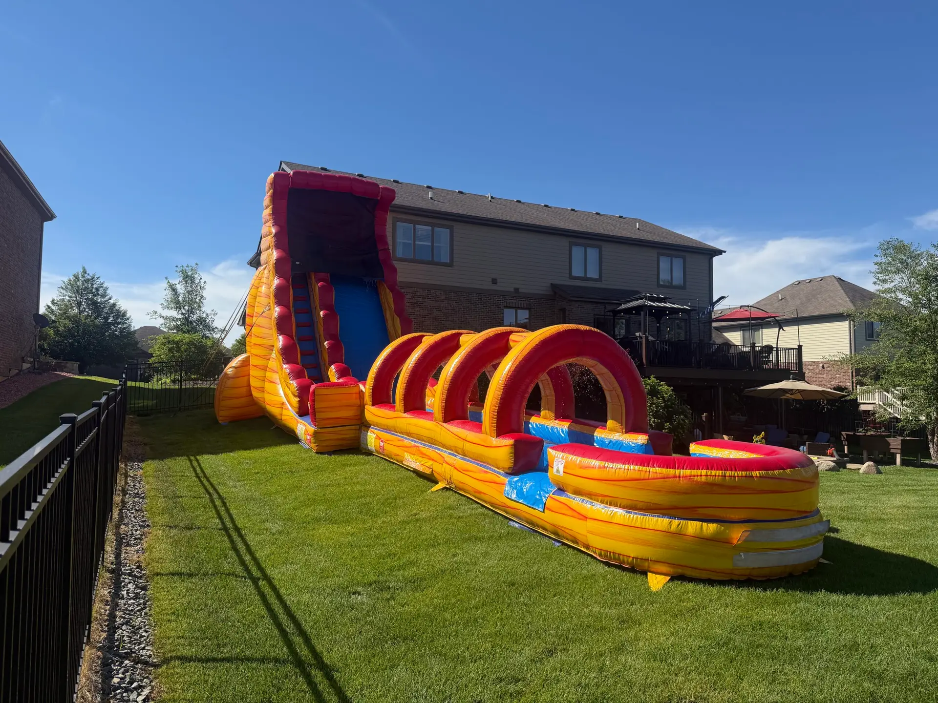 22-foot Volcano Water Slide with attached Slip N Slide set up in a backyard by Best Bounce Party Rentals in Tinley Park, Illinois